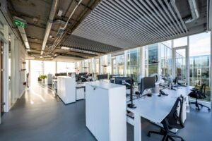 Moderne, open kantoorruimte aan de Fred. Roeskestraat met werkplekken, grote ramen en industrieel plafond.